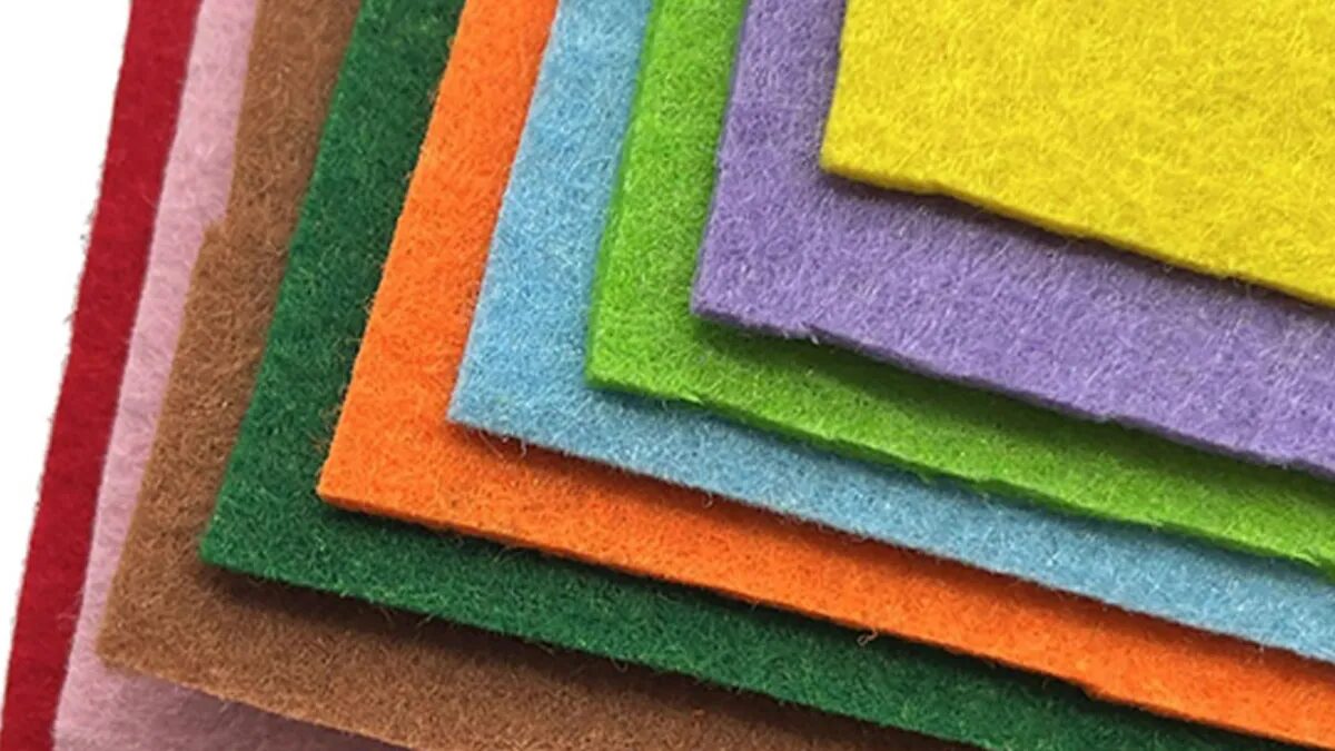 A fanned stack of colorful felt sheets in red, pink, tan, green, orange, blue, lime, lavender, and yellow.